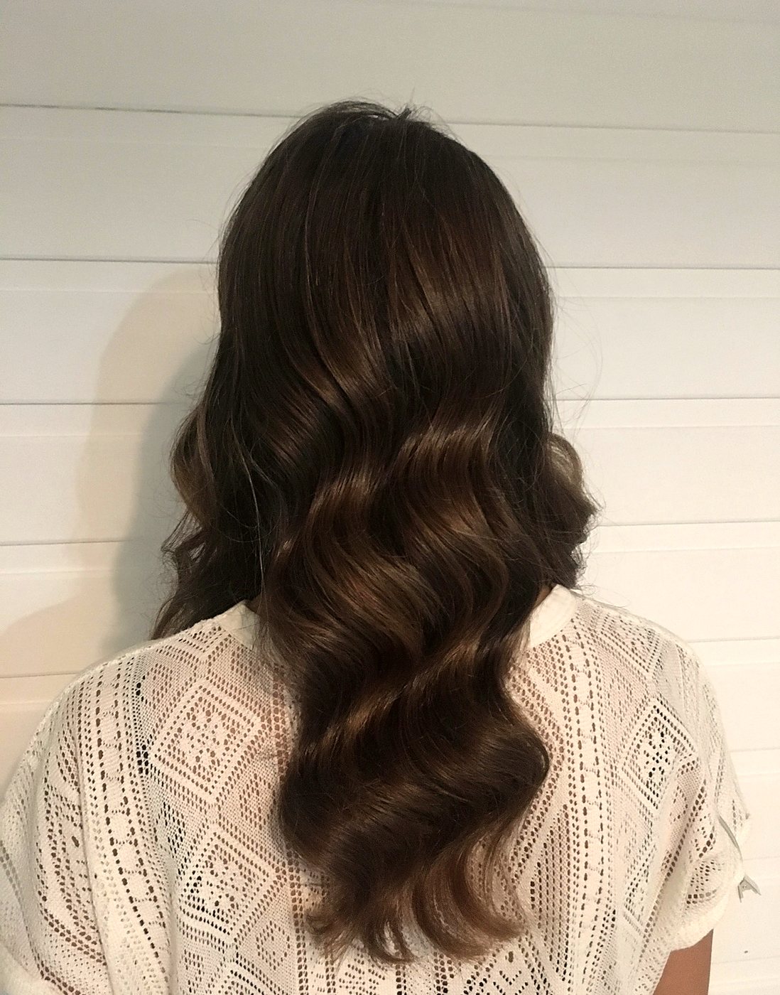 Glossy Hollywood waves on dark hair, seen from behind